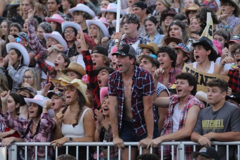 Jace Trautner (22) leads the Stang Gang in cheering for the football team after they scored a touchdown in the second quarter of the home game against Fivay High School on Aug. 27. Photo by: Emma Diehl