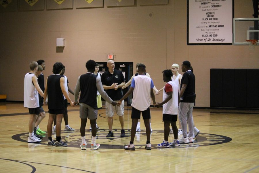 Coach Jason Vetter and his players gather up in a circle to encourage and inform the players of upcoming games and events. After finishing his talk with the team, they gathered into two groups and started their practice for their upcoming game of the season on Nov. 30. 
