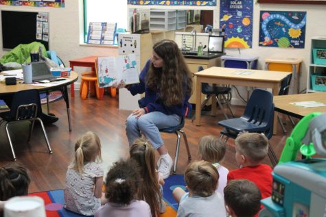 Sitting in the front of the class Haberlin reads a Dr. Seuss book from home to read to the preschool students. Taking her second trip Haberlin plans to return to the school to visit the kids again.