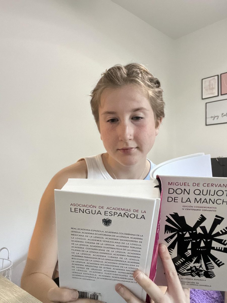  Lucy Breitenbach (‘24) reads a book after completing her homework. “I like reading books because they help open my perspective and experience new places without the cost of traveling,” she said. 